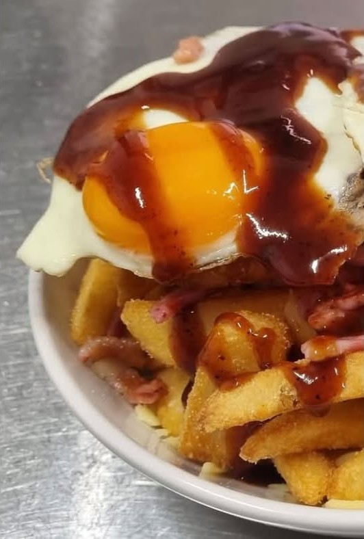 Close up of the Texas breakfast with a sunny side egg and house BBQ sauce